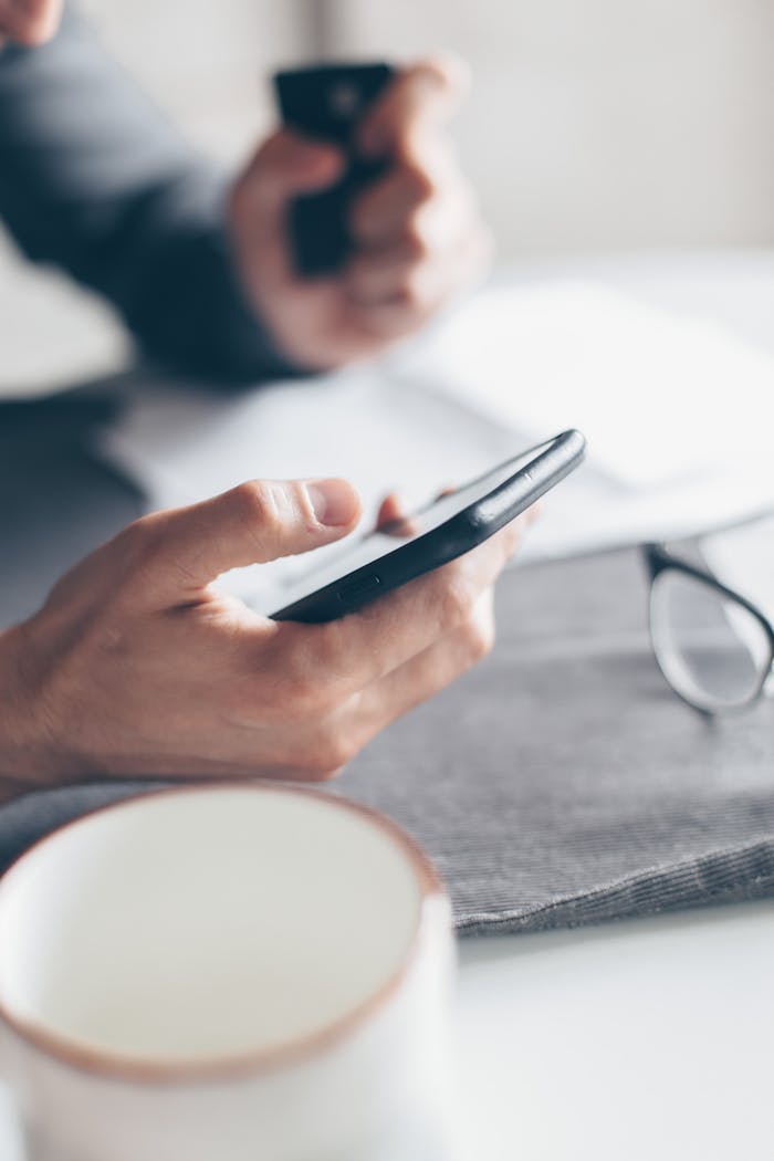 Home Hands holding a smartphone and credit card for online payment, emphasizing cashless transactions.